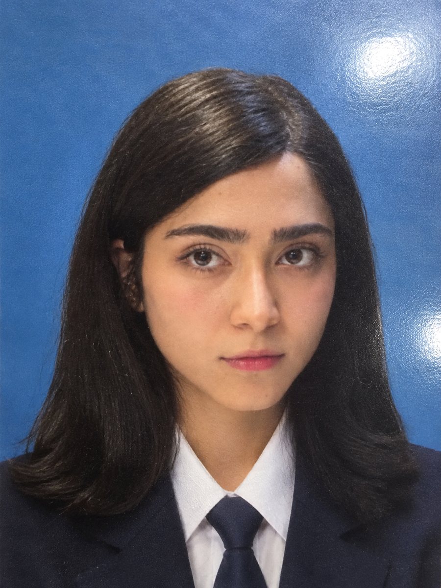 Portrait of Negar Zahed in a navy blazer, white shirt and tie